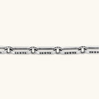 Sterling silver bar-link chain bracelet with oxidized Gothic text engravings and toggle clasp, 7.3mm wide, on white background.