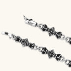 Oxidized 925 sterling silver bracelet with fleur-de-lis cross links, black-accented beads, and a cylindrical clasp stamped 2024.