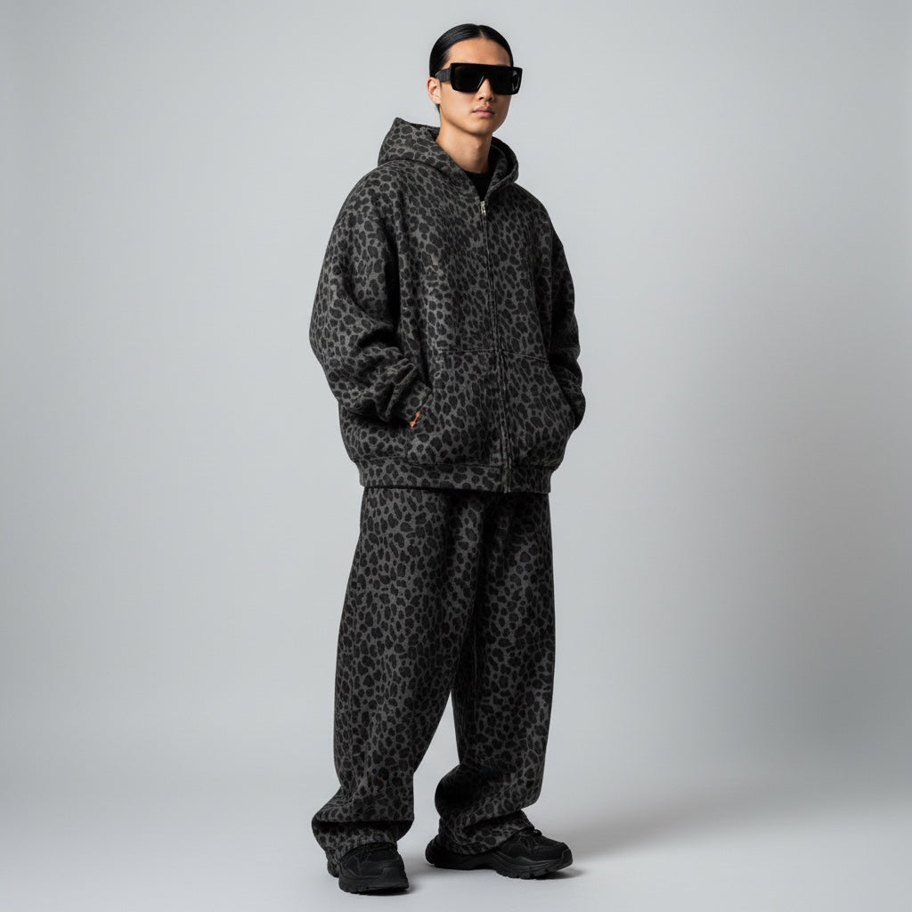 Model wearing an Anointed Garments grey and black animal print zip-up hoodie and matching oversized sweatpants.