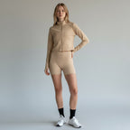 Model wearing Anointed Garments beige cropped long sleeve mock neck zip up jacket with matching athletic shorts.