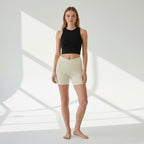 Model wearing Anointed Garments high-waisted beige athletic shorts with a crossover waistband and side pockets