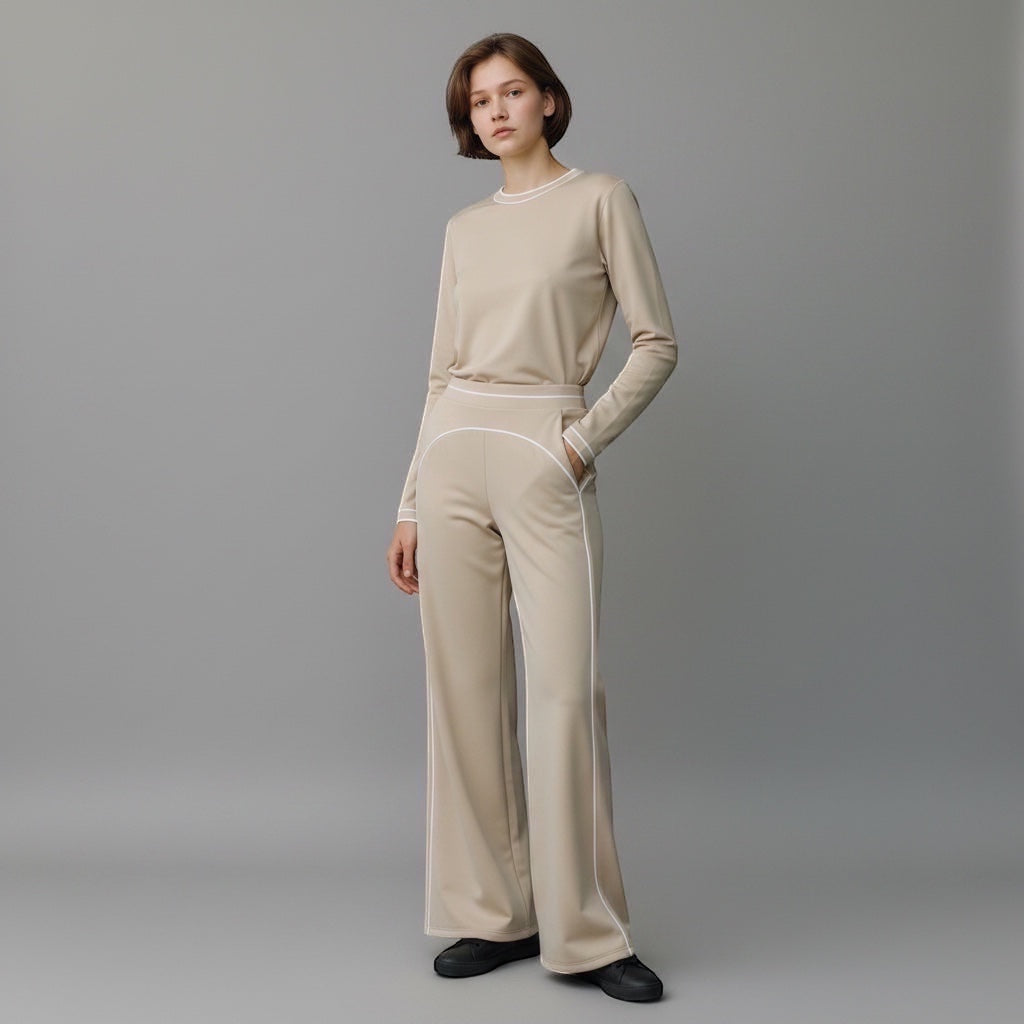 Model wearing Anointed Garments beige high-waisted wide-leg trousers with white contrast piping and matching top