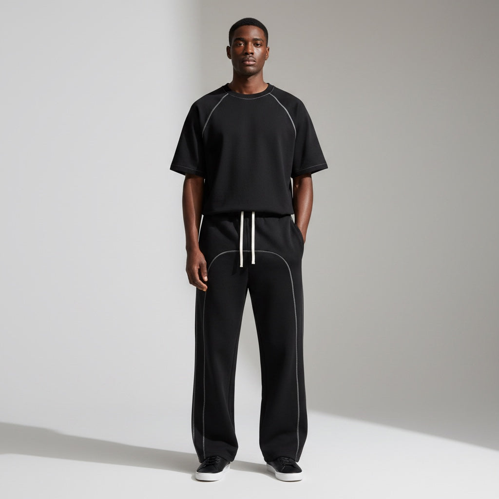 Anointed Garments black relaxed fit sweatpants with white contrast stitching and drawstring on a male model