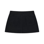 Back view of Anointed Garments black denim mini skirt featuring two patch pockets and a clean A-line silhouette.
