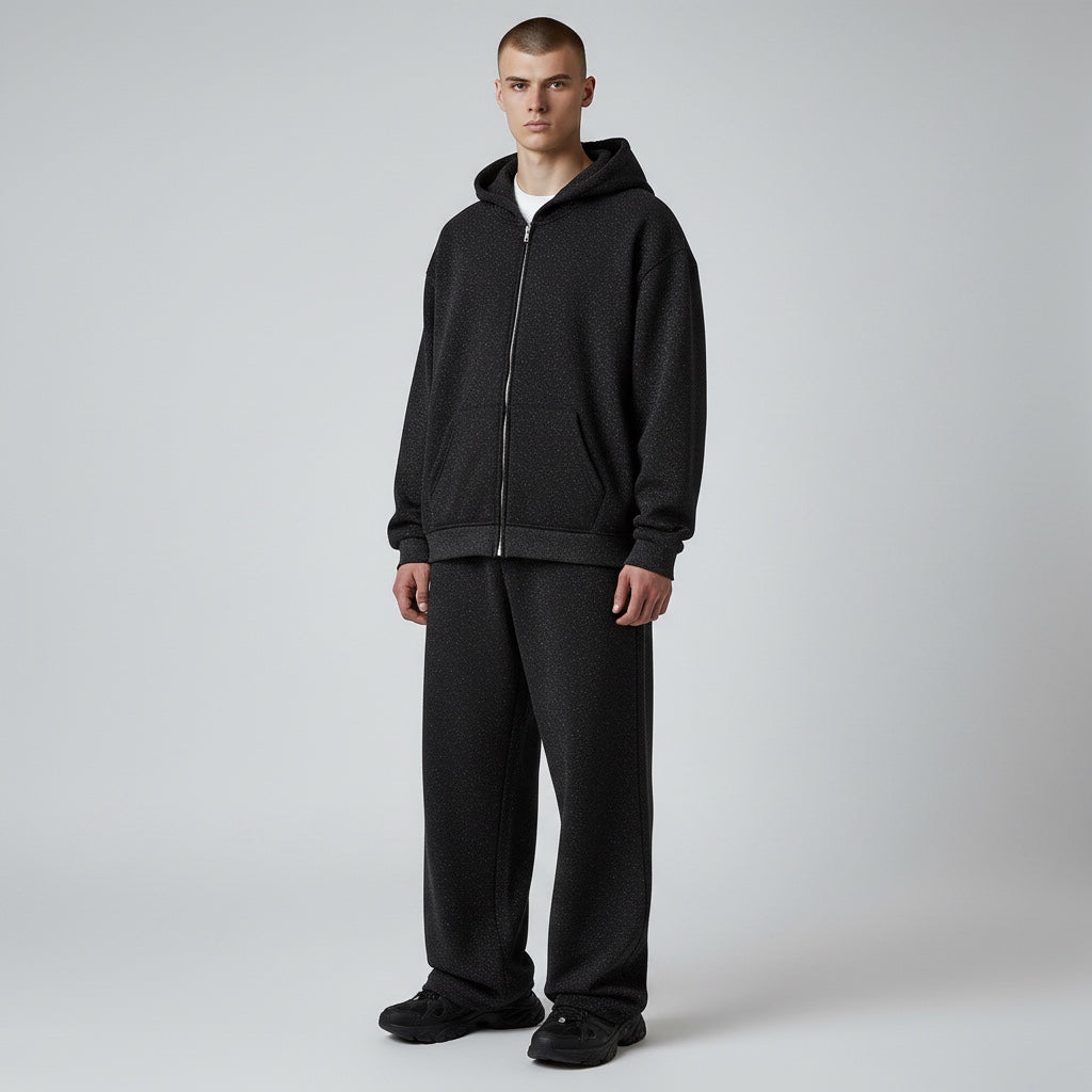 Model wearing an Anointed Garments Essential black full zip hoodie and matching sweatpants in a relaxed fit.