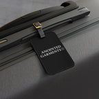 Anointed Garments black luggage tag attached to a textured hard shell suitcase handle