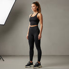 Anointed Garments black racerback performance crop tank top worn by a woman with matching leggings in a studio