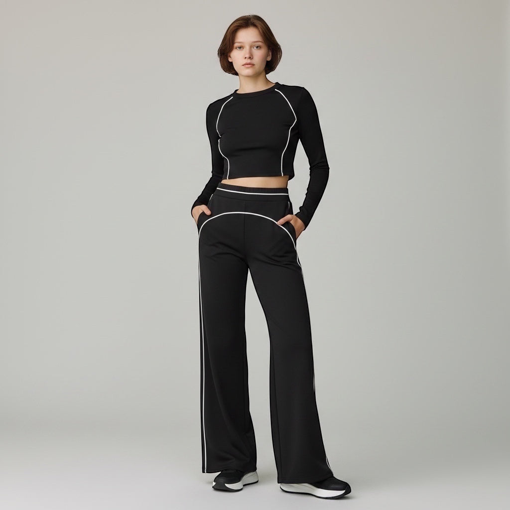 Anointed Garments high-waisted black wide-leg trousers with white contrast piping worn by a model with a matching top.