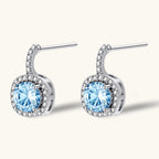 Anointed Garments Celestial Halo drop earrings featuring round blue moissanite stones in platinum-plated silver.