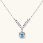 Anointed Garments Celestial Arc necklace in platinum-plated sterling silver with a blue moissanite V-shaped pendant.