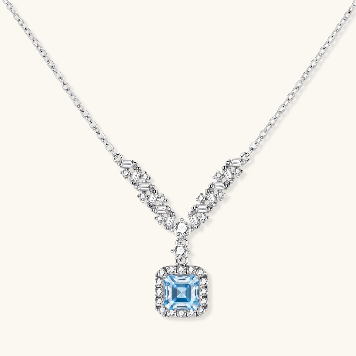Anointed Garments Celestial Arc necklace in platinum-plated sterling silver with a blue moissanite V-shaped pendant.