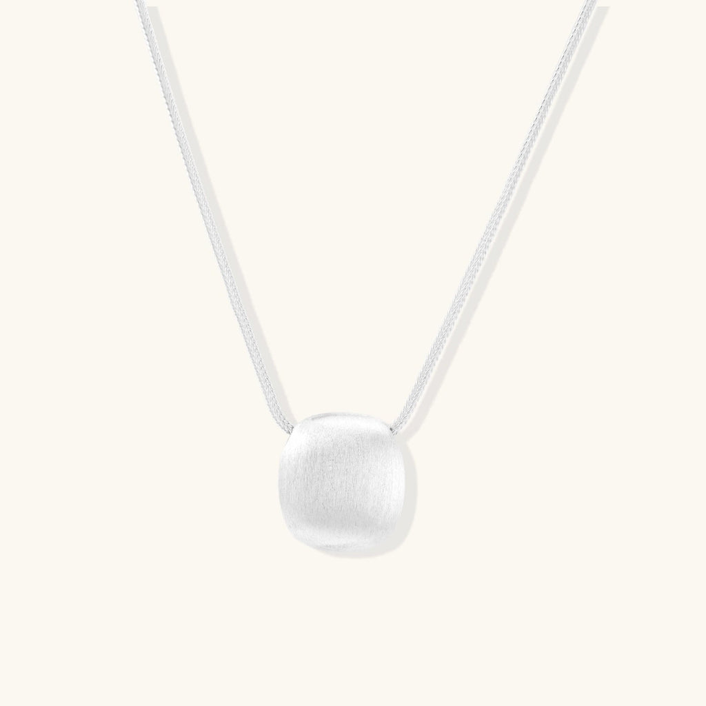 Anointed Garments brushed sterling silver disc pendant necklace on an adjustable chain with a soft matte finish.