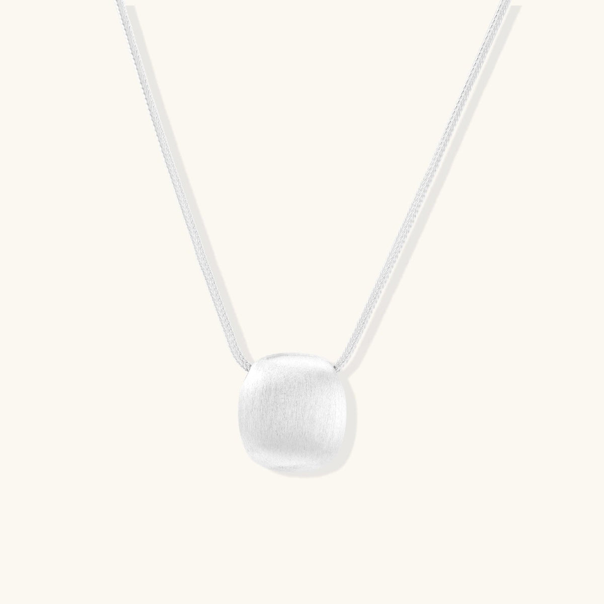 Anointed Garments brushed sterling silver disc pendant necklace on an adjustable chain with a soft matte finish.