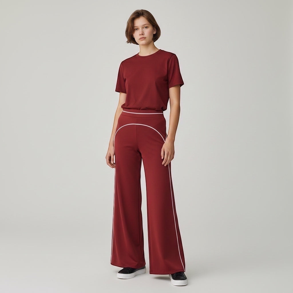 Anointed Garments high-waisted wide-leg trousers in burgundy with white contrast piping, worn with a matching t-shirt.