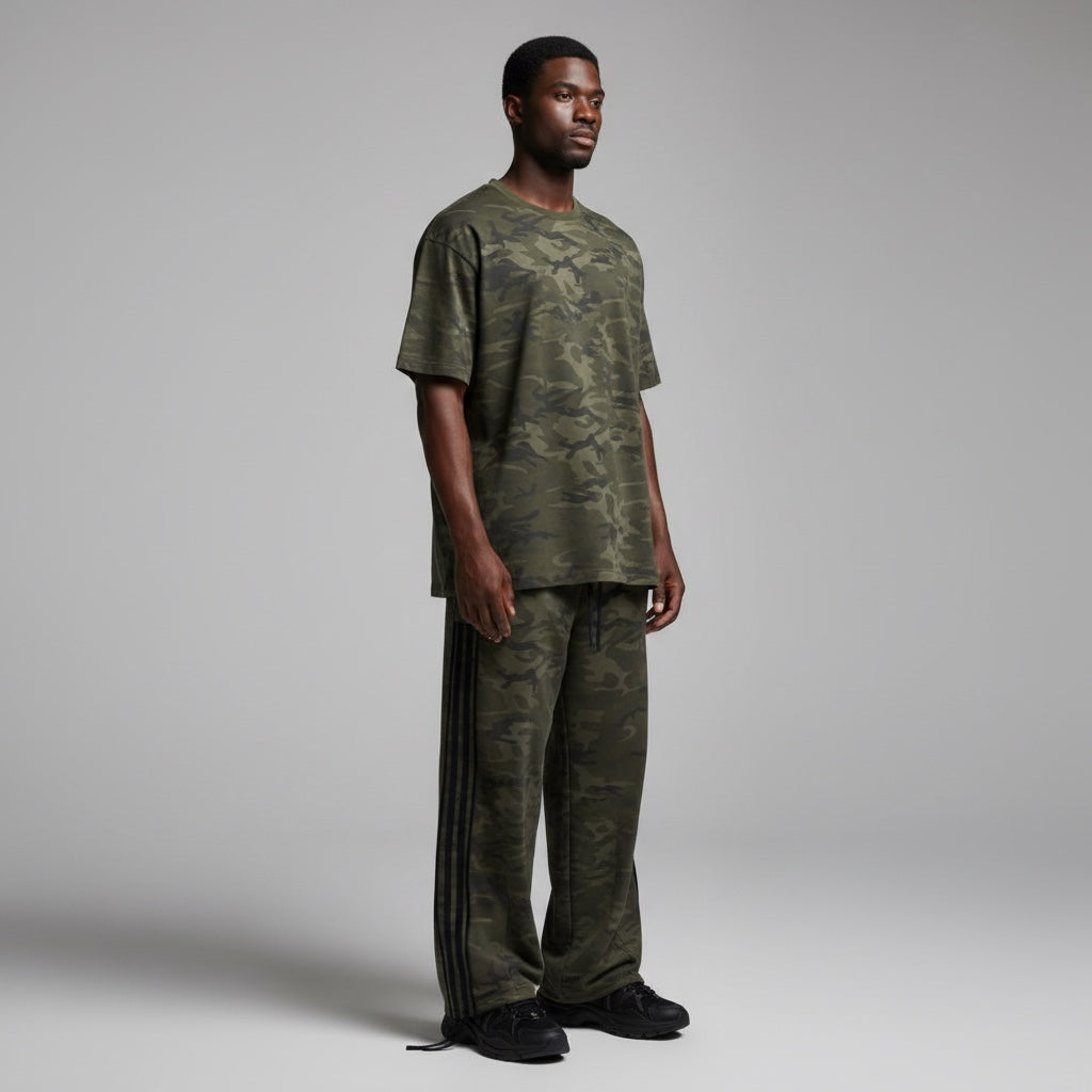 Anointed Garments wide leg camouflage track pants with black side stripes worn by a model in a matching camo t-shirt.