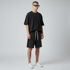 Model wearing Anointed Garments charcoal acid-wash cotton lounge shorts with raw-edge hem and drawstring waist