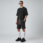 Model wearing Anointed Garments charcoal acid-wash cotton lounge shorts with a drawstring waist and raw-edge hem.
