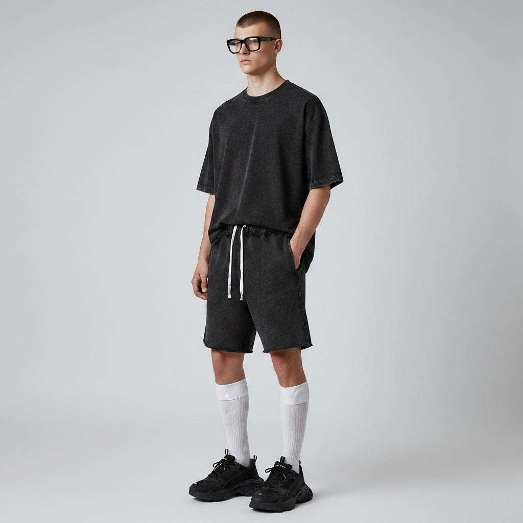 Model wearing Anointed Garments charcoal acid-wash cotton lounge shorts with a drawstring waist and raw-edge hem.