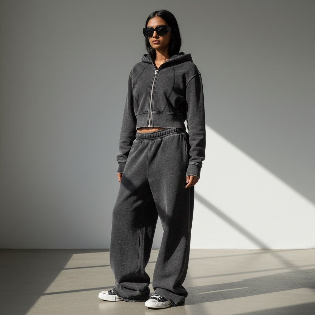 Model wearing an Anointed Garments vintage-washed charcoal grey cropped zip-up hoodie and matching wide-leg sweatpants.