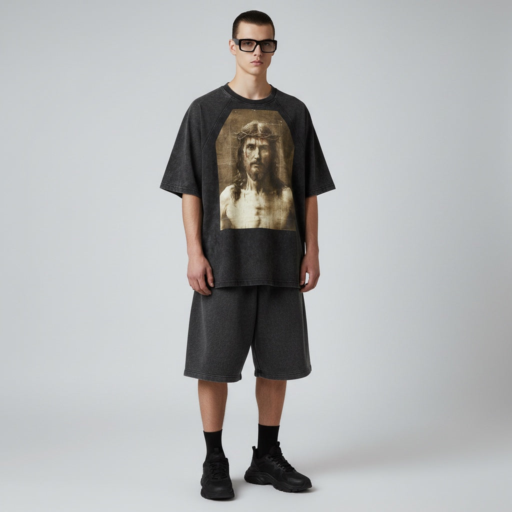 Model wearing an Anointed Garments charcoal black vintage-wash cotton graphic t-shirt with raglan sleeves and shorts.