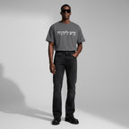Anointed Garments charcoal gray cotton t-shirt with white Hebrew script graphic worn by a model in black jeans.