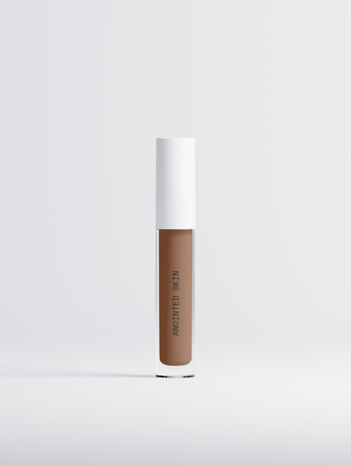 Anointed Skin Correcting Concealer in 35 Deep Neutral, a creamy, buildable formula in a sleek clear tube.