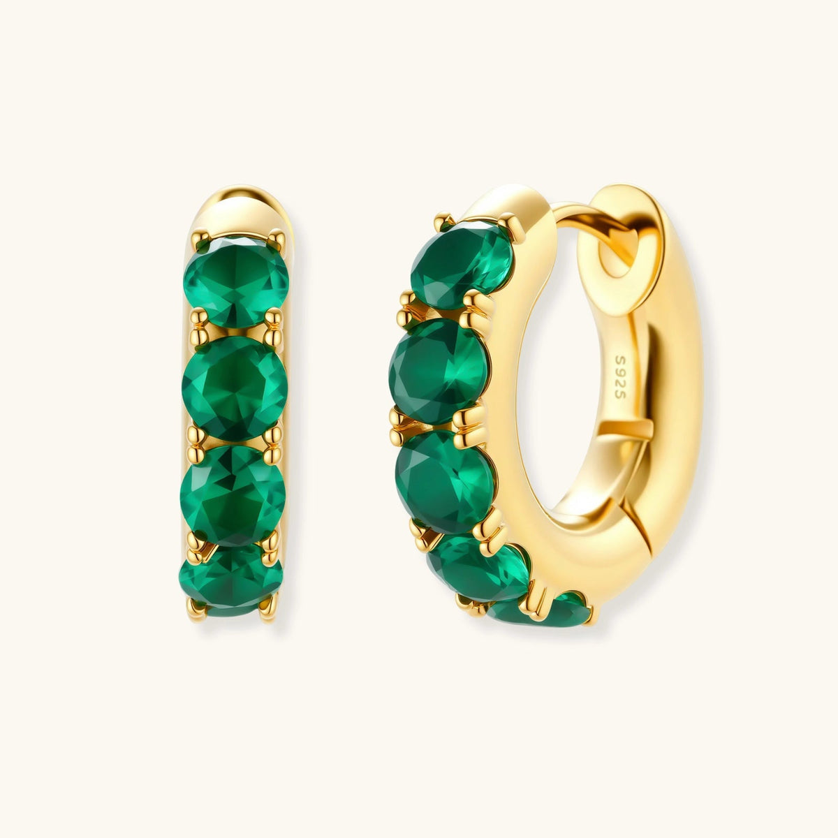 Anointed Garments emerald huggie hoops in 18K gold-plated sterling silver with green cubic zirconia stones.