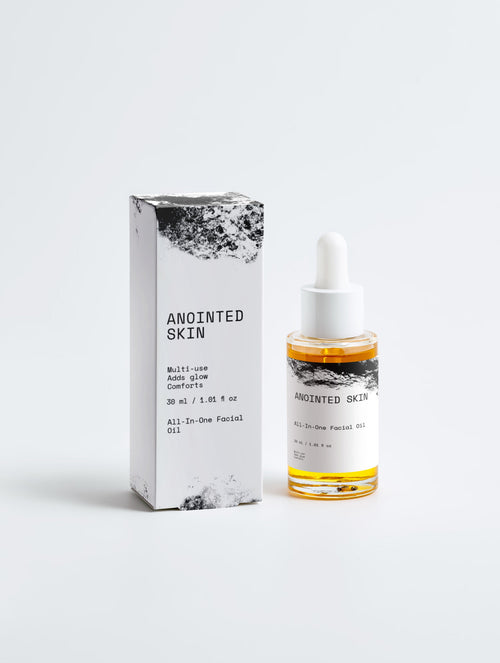 Anointed Garments ANOINTED SKIN facial oil bottle and white box packaging with black artistic texture details.