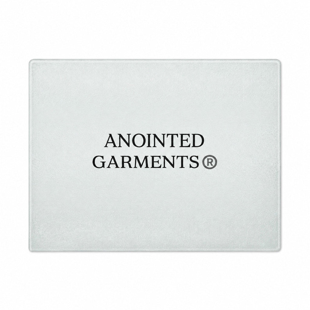 Anointed Garments tempered glass cutting board with a whorled texture and centered brand logo on a white background.