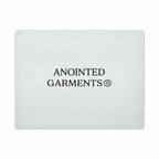 Anointed Garments tempered glass cutting board with a whorled texture and centered brand logo on a white background.