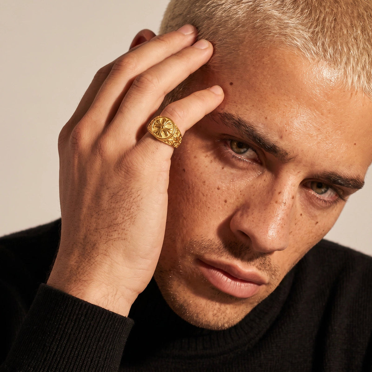 Anointed Garments gold cross signet ring with intricate filigree scrollwork worn on a man's finger