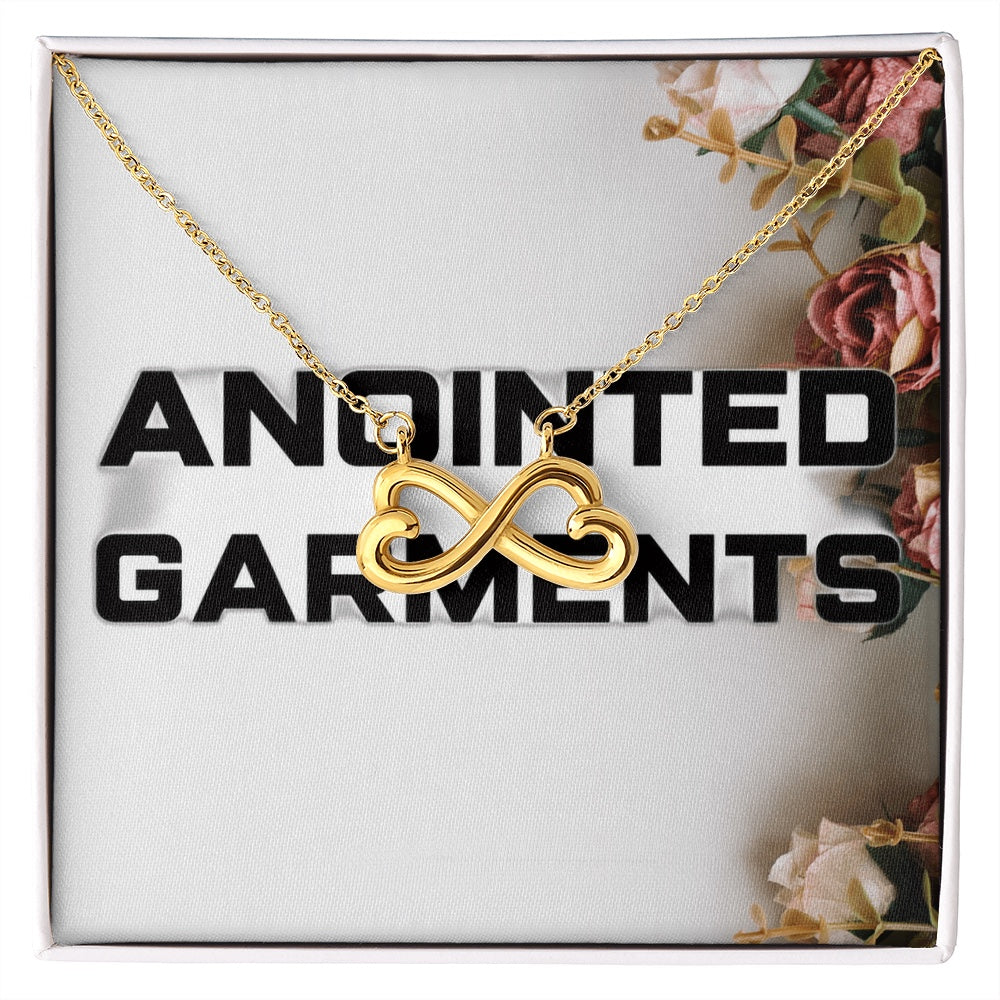 Anointed Garments 18k yellow gold heart infinity necklace on a cable chain in a floral gift box.