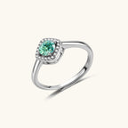 Anointed Garments Emerald Glow halo ring featuring a round green moissanite in a platinum-plated sterling silver setting.