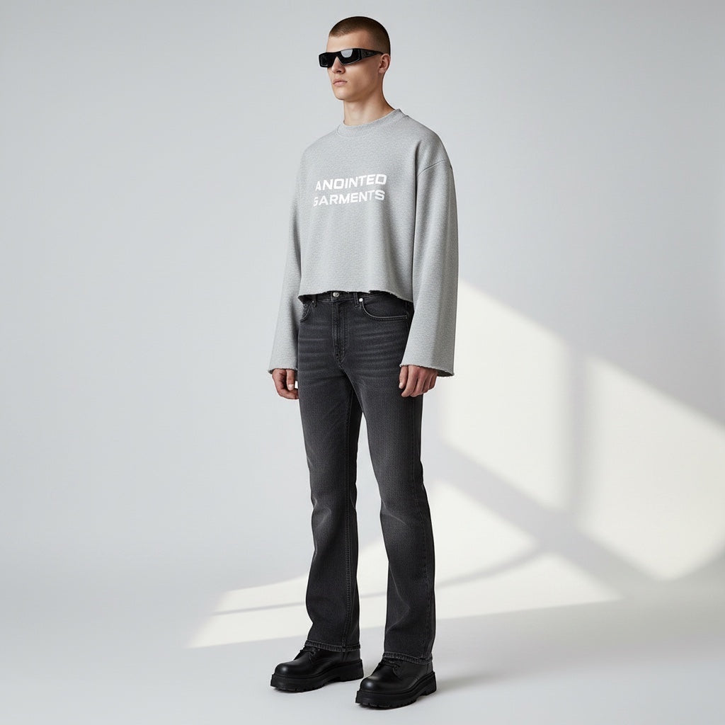 Model wearing Anointed Garments grey cropped crewneck sweatshirt with white chest branding and black jeans