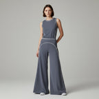 Anointed Garments grey high-waisted wide-leg trousers with white contrast piping worn with a matching sleeveless top