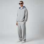 Model wearing Anointed Garments grey heavyweight cotton full zip hoodie with blue patterned hood lining and sweatpants