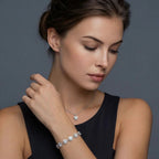 Anointed Garments heart moissanite necklace and bracelet set on a model wearing a black top against a grey background.