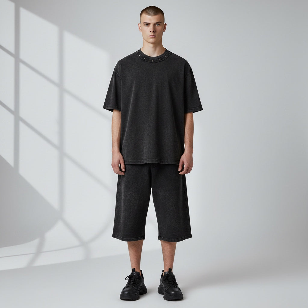 Anointed Garments heavyweight charcoal cotton t-shirt with metallic stud neckline, worn by a model in a studio.