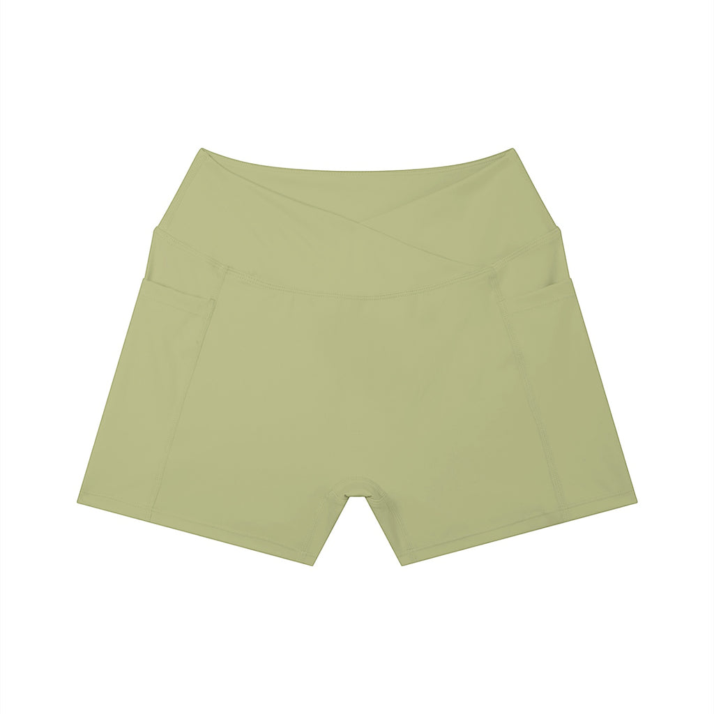 Anointed Garments high-rise yoga shorts in light olive green with side pockets and a flattering crossover waistband.