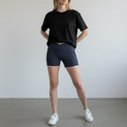 Anointed Garments high-waisted athletic performance shorts in dark blue with a crossover waistband and side pockets.
