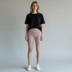 Model wearing Anointed Garments high-waisted athletic performance shorts in dusty pink with side pockets and black tee.