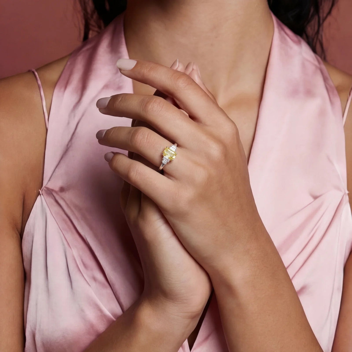Anointed Garments Golden Radiance Moissanite ring on a woman's hand, featuring a yellow stone in a platinum setting.