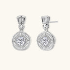 Anointed Garments celestial sunburst drop earrings in platinum-plated sterling silver with round-cut moissanite stones.