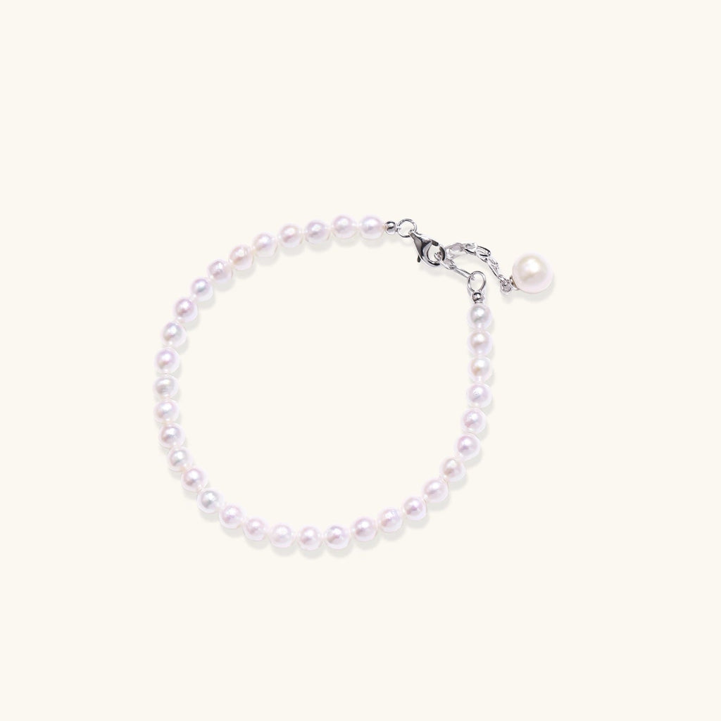 Anointed Garments Pearlescent Dreams bracelet featuring round freshwater pearls and a rhodium-plated silver pendant.