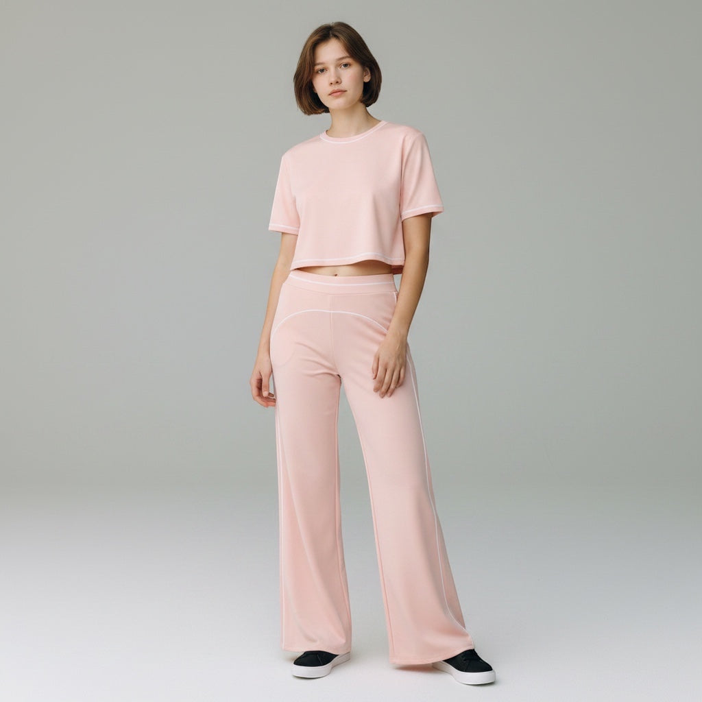 Model wearing Anointed Garments light pink high-waisted wide-leg trousers and matching cropped t-shirt with piping