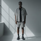 Anointed Garments model wearing a grey and white plaid short sleeve button down shirt and matching plaid shorts.