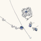 Anointed Garments rainbow moissanite jewelry set featuring a butterfly necklace, stud earrings, and a floral ring.