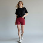 Anointed Garments high-waisted athletic shorts in deep red with side pockets, worn by a model in a black t-shirt.