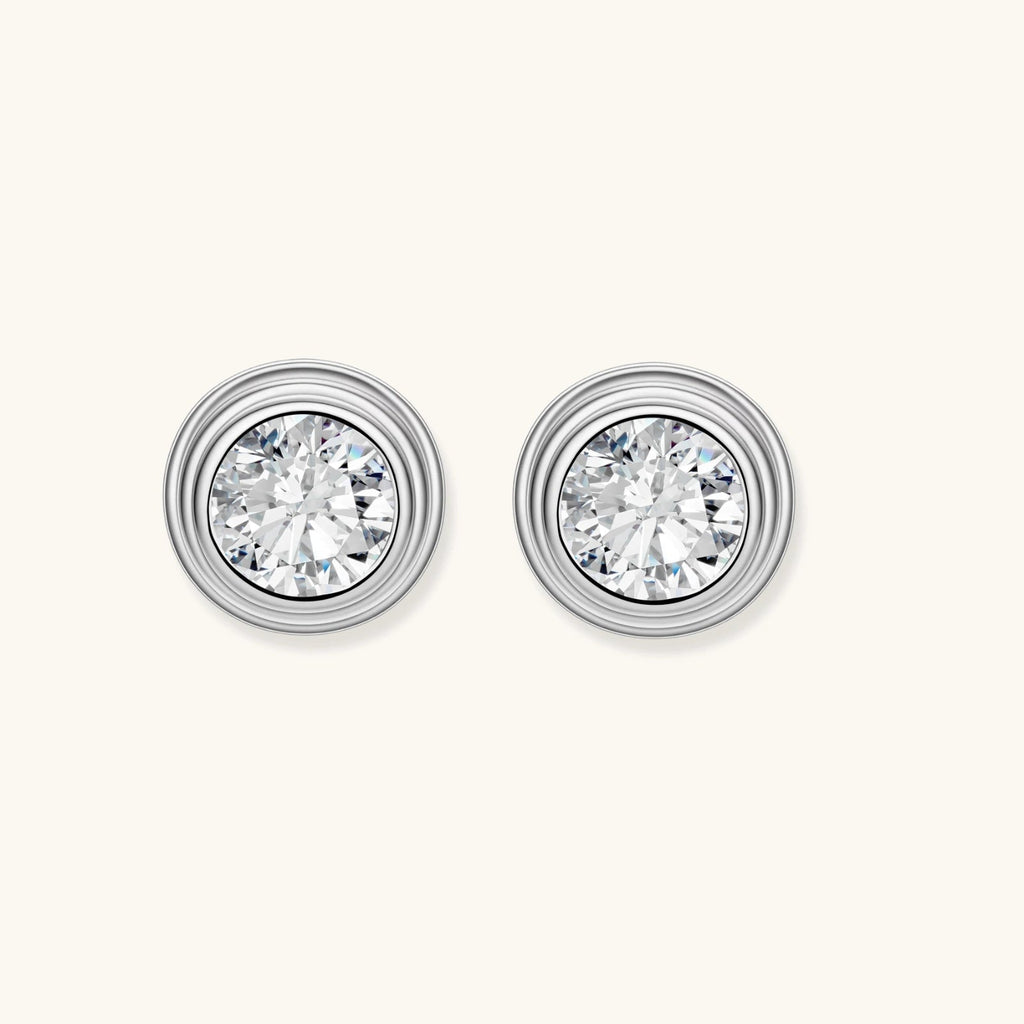 Anointed Garments round moissanite stud earrings in platinum-plated 925 sterling silver with concentric circle frames.