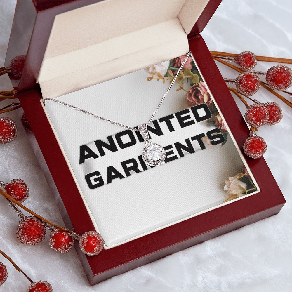 Anointed Garments round pendant necklace with a cubic zirconia center stone in a mahogany gift box with red berries.